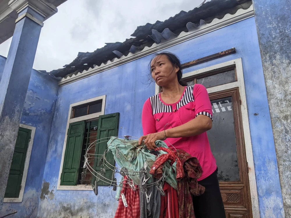 Căn nhà của bà Nguyễn Thị Mai bị bão cuốn đi. Trong ảnh: Con dâu bà Mai đang phụ mẹ dọn dẹp lại đồ đạc. Ảnh: NGUYỄN DO Căn nhà của bà Nguyễn Thị Mai bị bão cuốn đi. Trong ảnh: Con dâu bà Mai đang phụ mẹ dọn dẹp lại đồ đạc. Ảnh: NGUYỄN DO