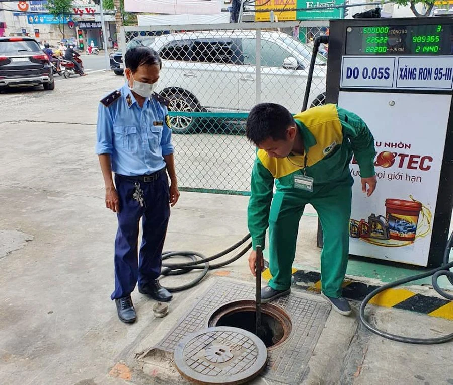 Kiểm tra, đo bồn tại cây xăng trên đường Hoàng Văn Thụ, phường 9, quận Phú Nhuận. Ảnh: NGUYỄN YÊN