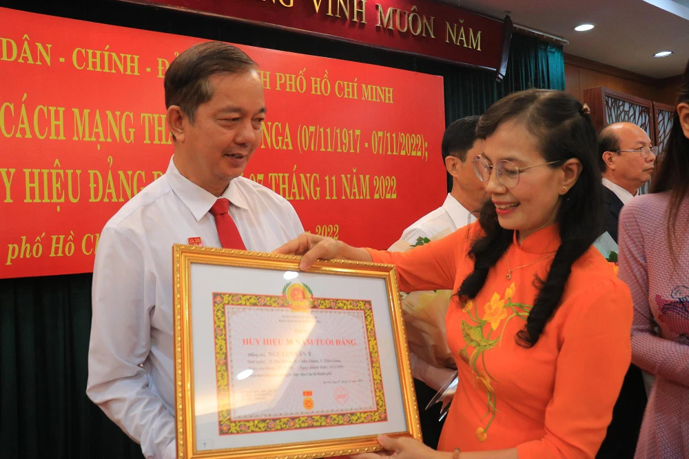 Bà Nguyễn Thị Kim Dung, Phó Bí thư Thường trực Đảng ủy Khối Dân - Chính - Đảng TP.HCM trao tặng Huy hiệu cho các đảng viên. Ảnh: VÕ THƠ