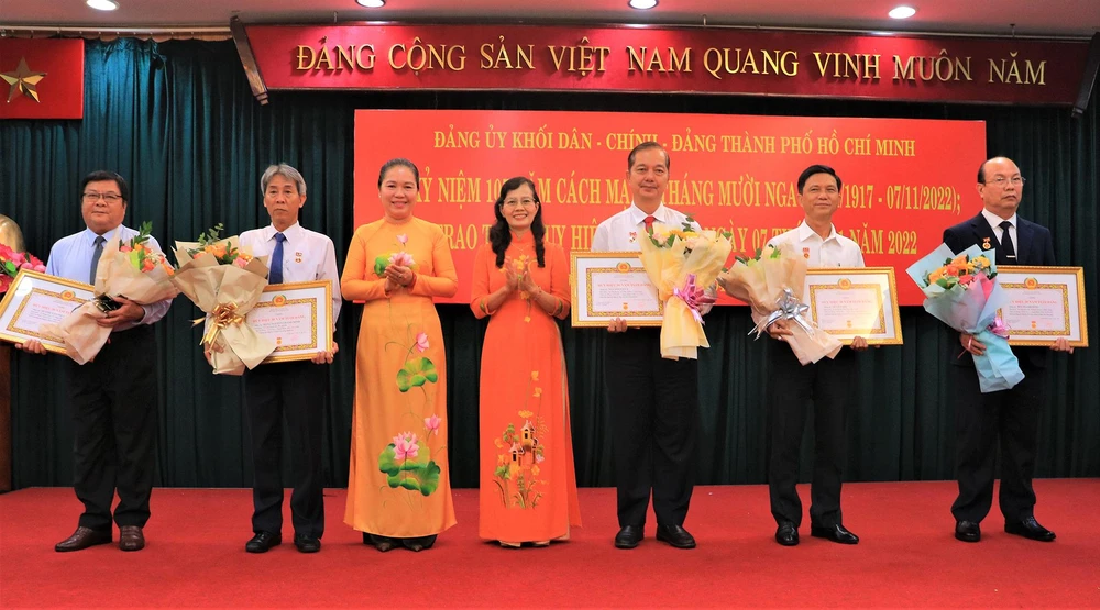 Bà Lê Thị Hồng Nga, Bí thư Đảng ủy Khối cơ sở Bộ Công Thương TP.HCM và bà Nguyễn Thị Kim Dung, Phó Bí thư thường trực Đảng ủy Khối Dân - Chính - Đảng TP.HCM trao tặng Huy hiệu Đảng cho các đảng viên. Ảnh: VÕ THƠ