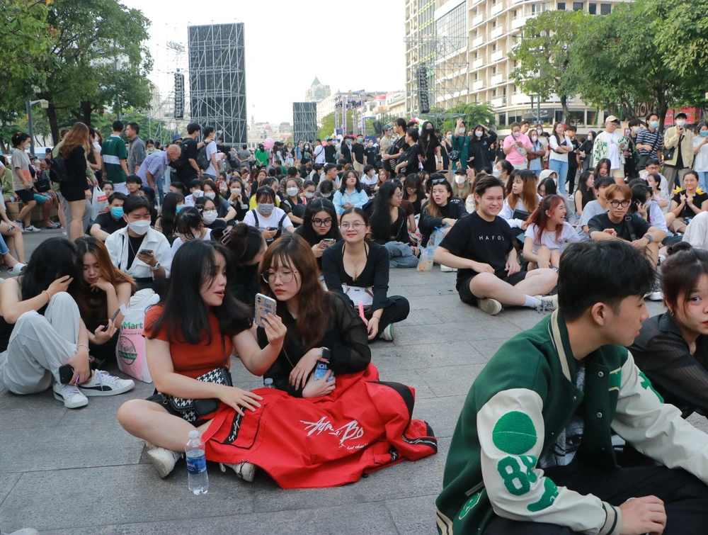 Nhiều bạn trẻ do đến quá sớm, phải ngồi dưới đất, mua sẵn đồ ăn, nước uống trong lúc ngồi đợi countdown 2023. Ảnh: BẢO PHƯƠNG