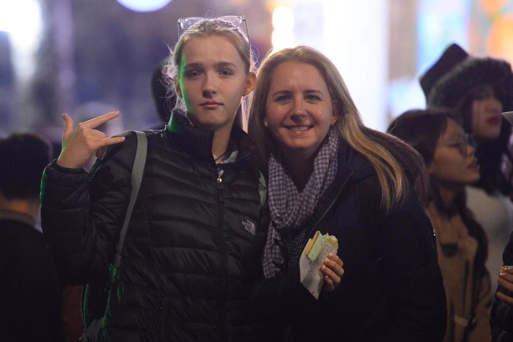 Du khách nước ngoài cùng hòa mình vào không khí đón chào năm mới. Ảnh: PHI HÙNG