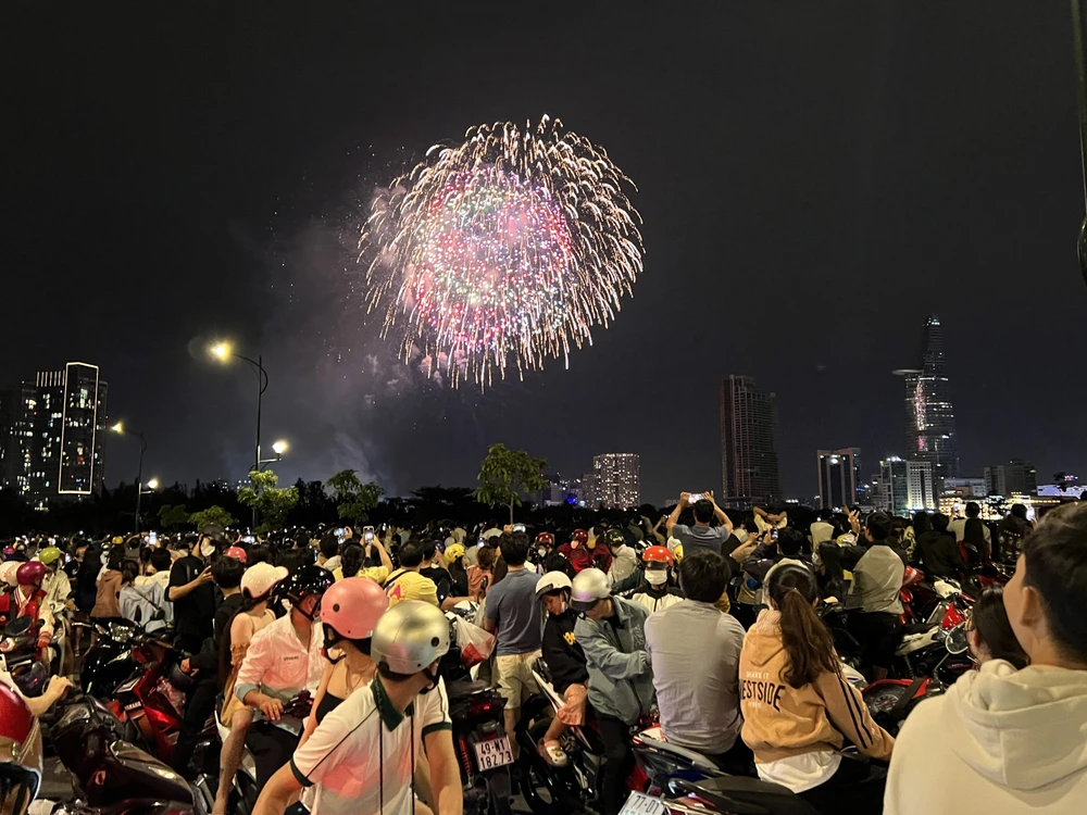 Người dân TP.HCM theo dõi những màn bắn pháo hóa ở khu vực cầu Thủ Thiêm. Ảnh: NHẬT DIỄM