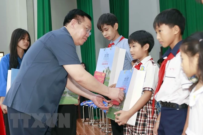 Chủ tịch Quốc hội Vương Đình Huệ tặng quà Tết các cháu mồ côi được Bộ Chỉ huy Bộ đội Biên phòng tỉnh An Giang nuôi dưỡng. Ảnh: TTXVN Chủ tịch Quốc hội Vương Đình Huệ tặng quà Tết các cháu mồ côi được Bộ Chỉ huy Bộ đội Biên phòng tỉnh An Giang nuôi dưỡng. Ảnh: TTXVN