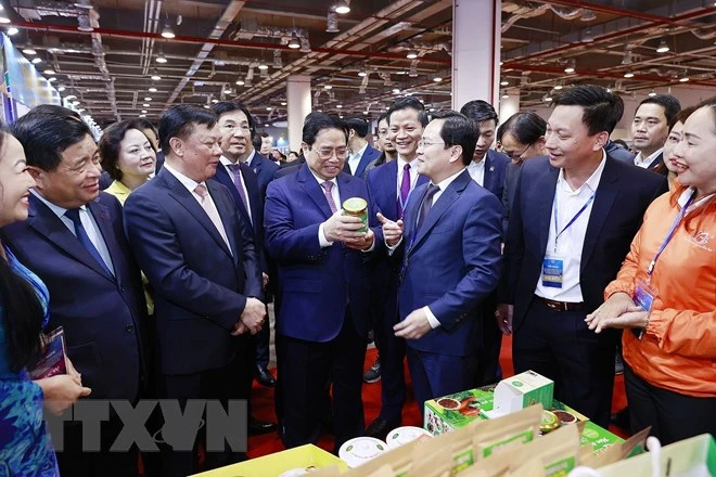 Thủ tướng xem trưng bày sản phẩm nông nghiệp, thủ công, mỹ nghệ của các tỉnh Vùng Đồng bằng sông Hồng. Ảnh: TTXVN