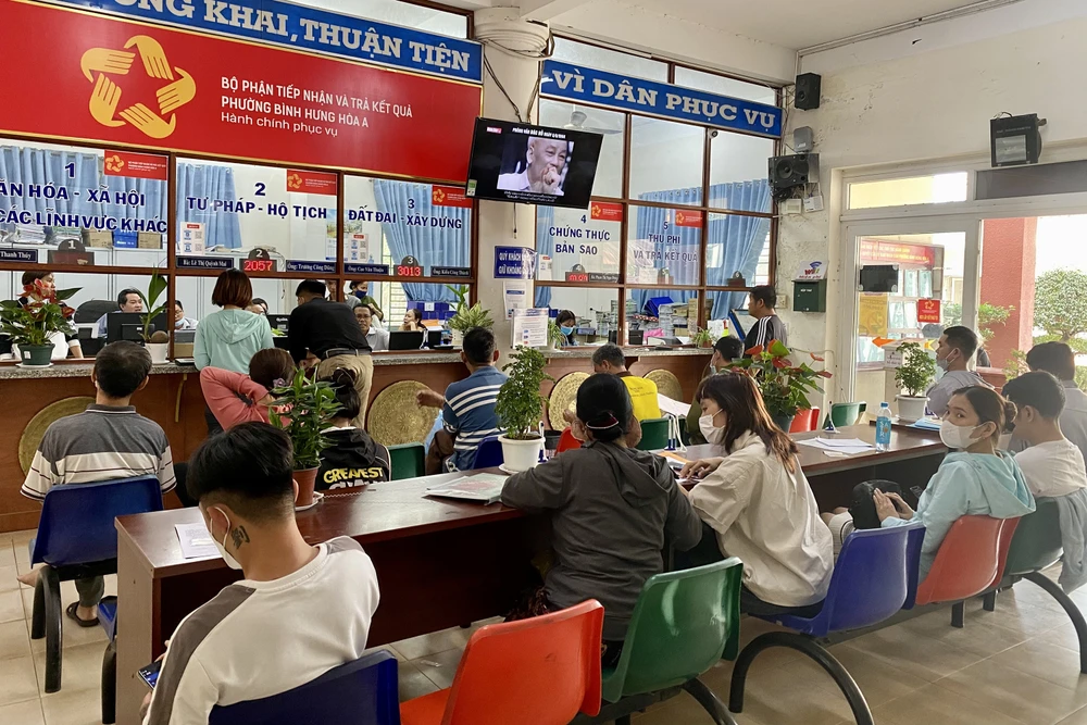 Người dân phường Bình Hưng Hoà A ngồi chờ đến lượt làm thủ tục trước bộ phận tiếp nhận và trả kết quả. Ảnh: BẢO PHƯƠNG