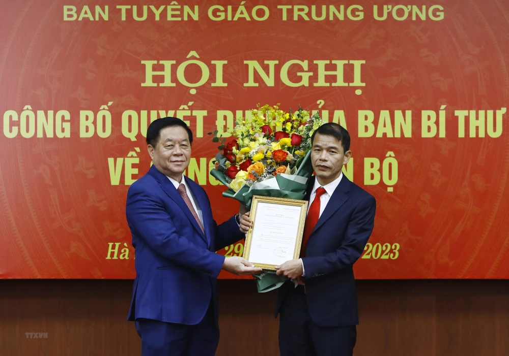 Trưởng Ban Tuyên giáo Trung ương Nguyễn Trọng Nghĩa trao quyết định, hoa chúc mừng cho ông Vũ Thanh Mai (phải). Ảnh: TTXVN