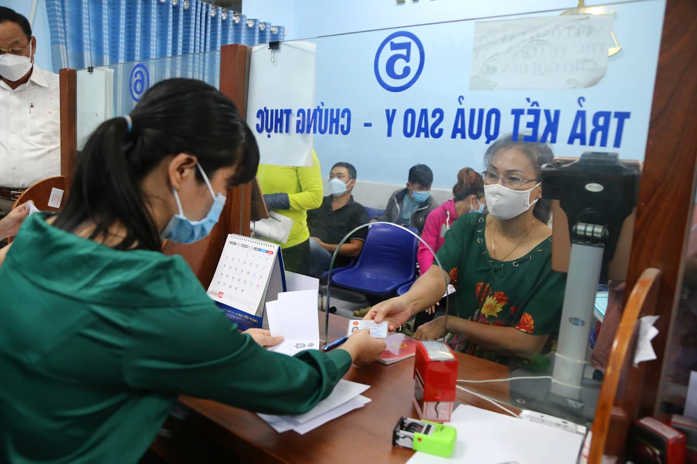 Tình trạng một bộ phận cán bộ đang có sự e ngại, thiếu tính chủ động, sáng tạo, chưa quyết liệt trong thực hiện các công việc, đang diễn ra ở nhiều nơi. Trong ảnh: Cán bộ UBND xã Vĩnh Lộc A, huyện Bình Chánh, TP.HCM đang hỗ trợ người dân làm thủ tục hành chính. Ảnh: HOÀNG GIANG