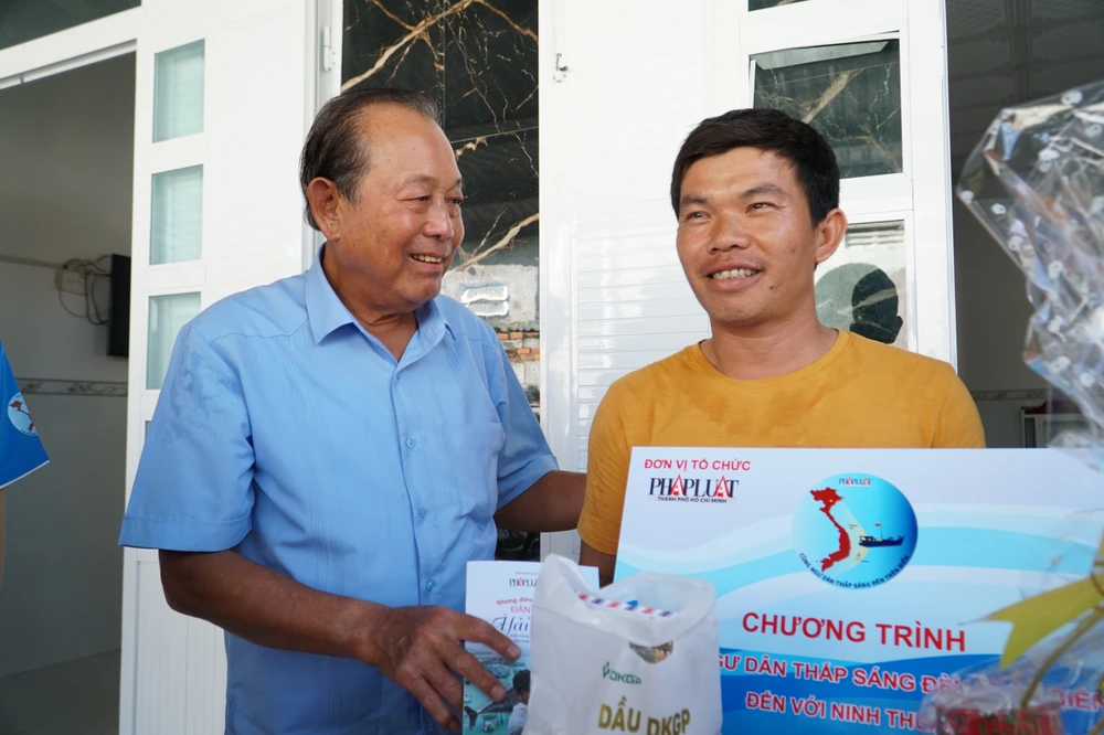 Nguyên Phó Thủ tướng Thường trực Trương Hoà Bình gửi những phần quà tới ngư dân Nguyễn Văn Sang. Ảnh: NHẬT DIỄM