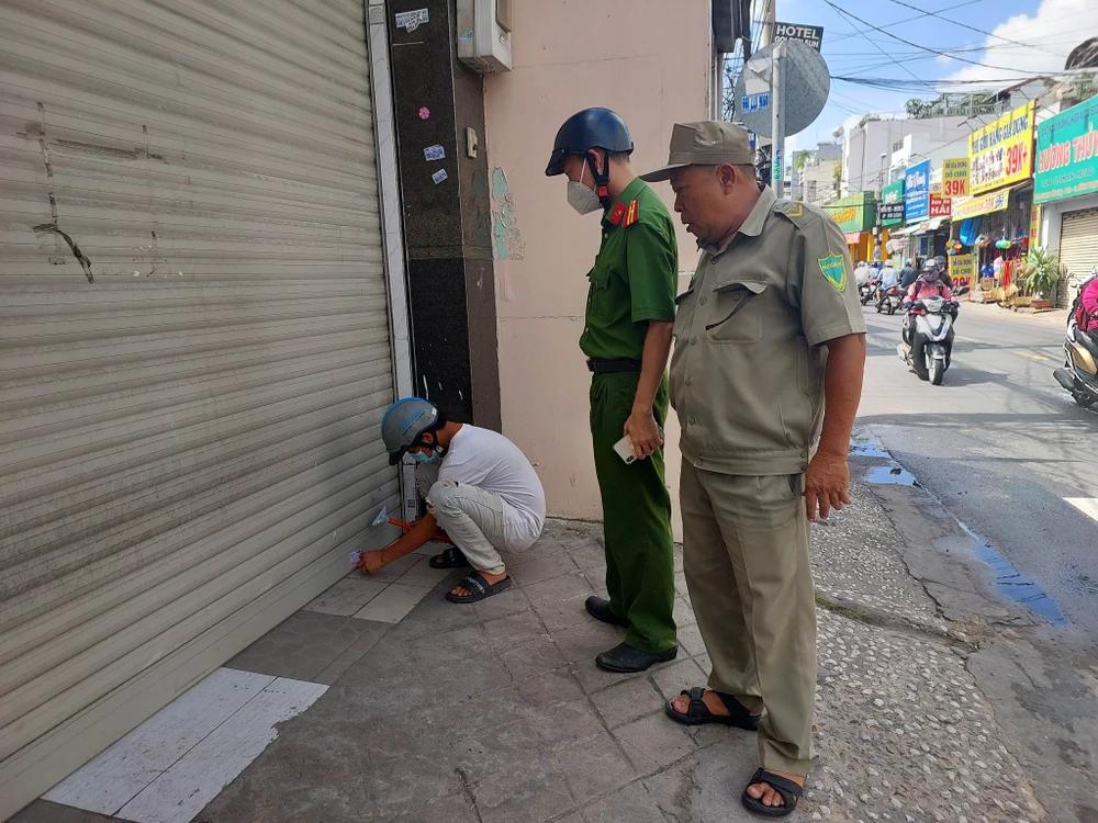 Lực lượng chức năng đưa người vi phạm đi tháo gỡ các tờ rơi, quảng cáo đã dán trước đó. Ảnh: ĐC