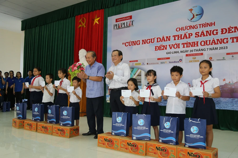 Ông Trương Hòa Bình, nguyên Phó Thủ tướng Thường trực, Chủ tịch danh dự của Chương trình và ông Mai Ngọc Phước, Tổng biên tập báo Pháp Luật TP.HCM, Trưởng Ban Chỉ đạo chương trình, tặng quà và học bổng cho các em học sinh có hoàn cảnh khó khăn.