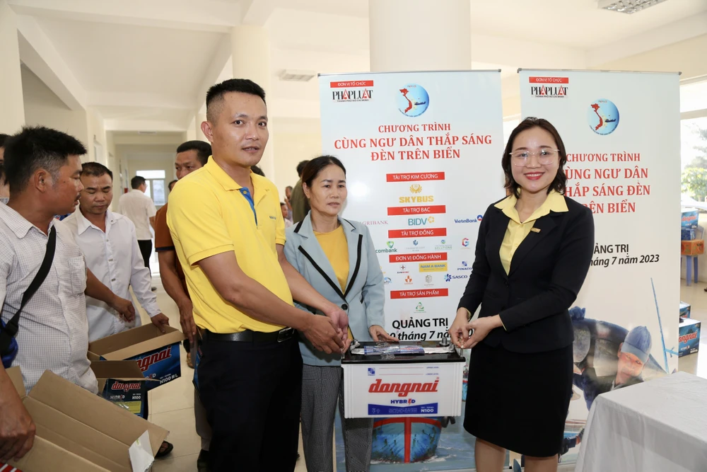 Chị Nguyễn Thị Kim Ngọc (bên phải), Phó Giám đốc Nam A Bank Thừa Thiên - Huế, tặng quà cho ngư dân.