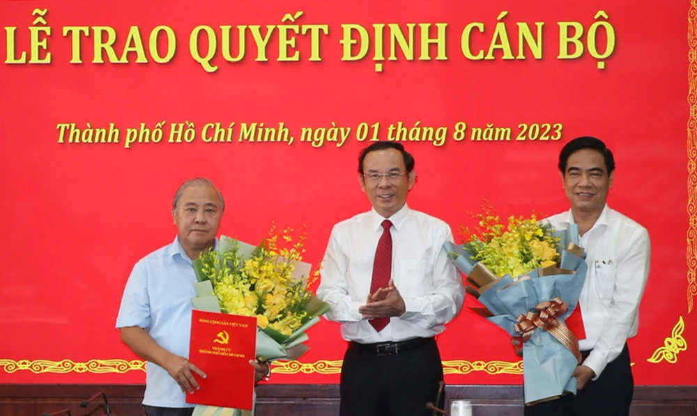 Bí thư Thành ủy TP.HCM Nguyễn Văn Nên trao quyết định nghỉ hưu cho ông Võ Văn Tân (bên trái) và ông Ngô Văn Luận (bên phải). Ảnh: THANH THUỲ