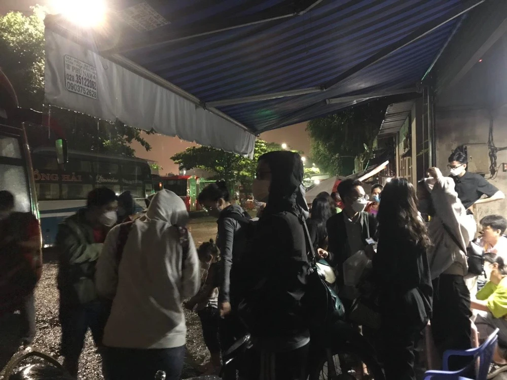 Khoảng 19 giờ khu vực bến xe Miền Đông vẫn có mưa rả rích, nhiều hành núp mưa chờ tới giờ xe khởi hành.