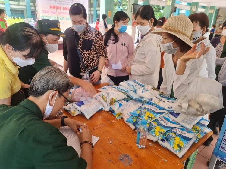 Người dân mang bóng đèn, pin đến đổi lấy quà. Ảnh: NGUYỄN CHÂU