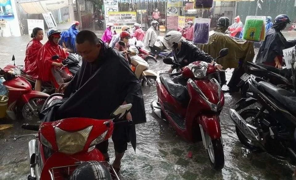 Người dân phải dừng xe trú mưa. Ảnh: TUYẾT TRINH Người dân phải dừng xe trú mưa. Ảnh: TUYẾT TRINH