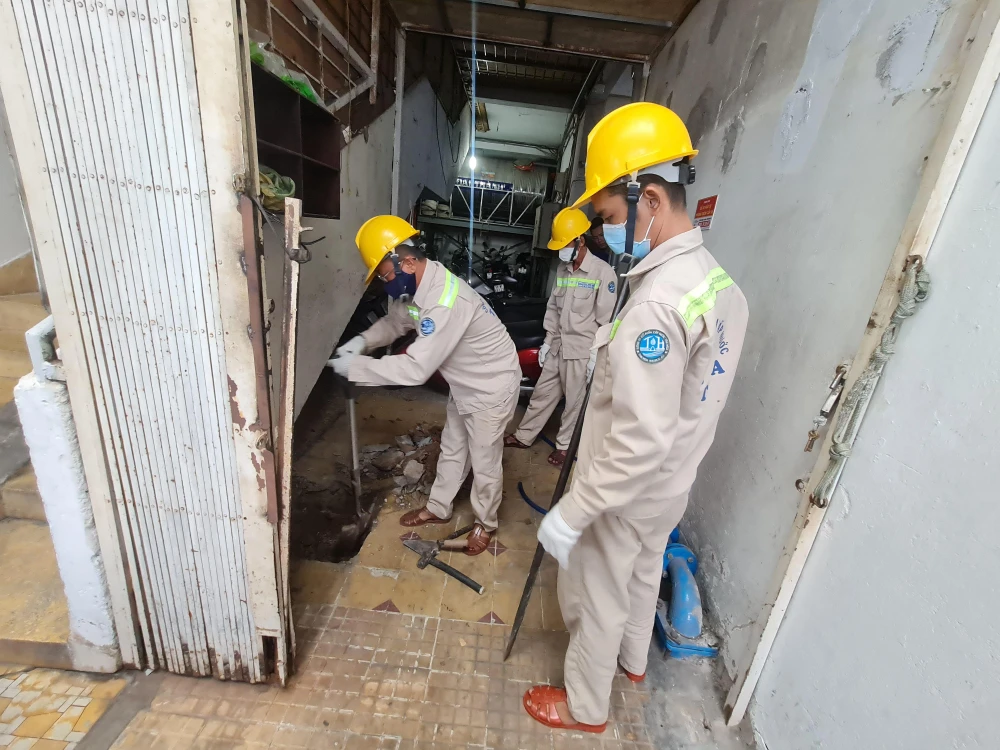 Công ty cổ phần Cấp nước Tân Hòa lấp giếng tại một chung cư thuộc quận Tân phú. Ảnh: NGUYỄN CHÂU