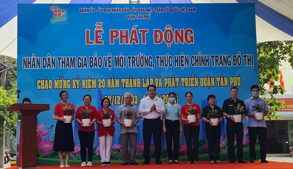 Lãnh đạo quận Tân Phú tặng cây xanh cho người dân. Ảnh: NC