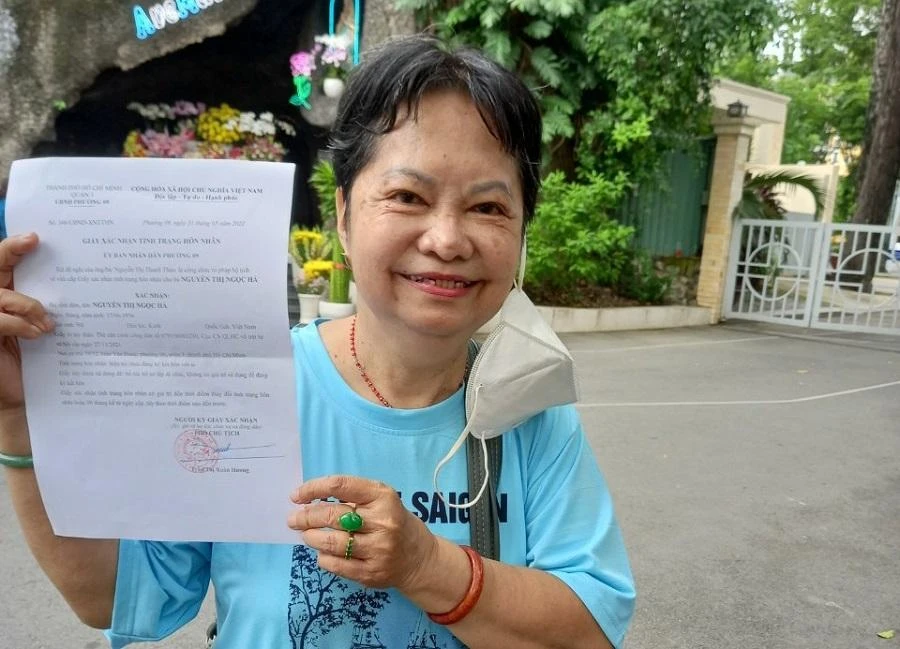 Bà Hà vui mừng khi được cấp giấy xác nhận độc thân. Ảnh: NGUYỄN HIỀN