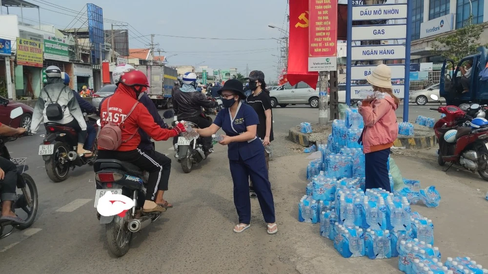 Nhóm từ thiện phát nước miễn phí cho người dân đang lưu thông trên đường. Ảnh: NGUYỄN HIỀN
