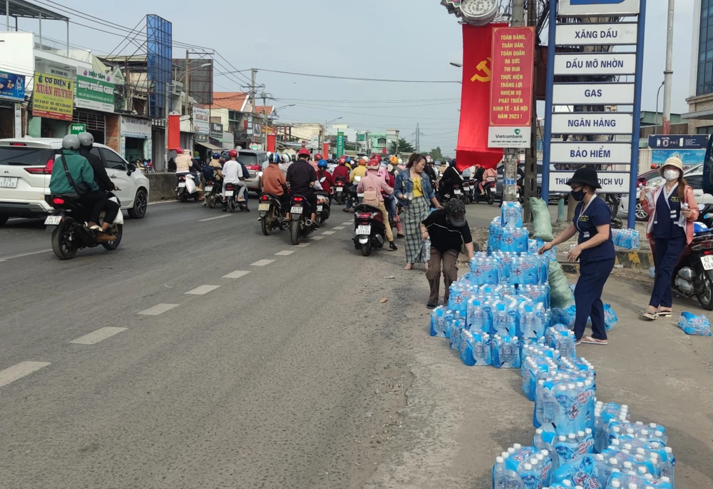 Nhóm từ thiện chuẩn bị hàng nghìn chai nước suối để phát miễn phí cho người đi đường. Ảnh: NGUYỄN HIỀN