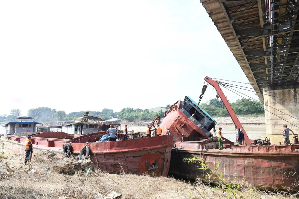 Huy động hàng chục cán bộ, phương tiện trục vớt tàu chìm mắc vào mố cầu Việt Trì.jpg