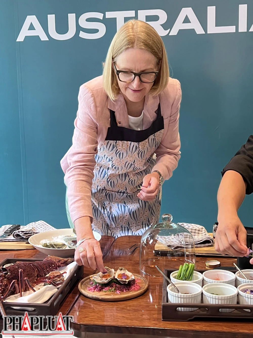 Tổng Lãnh sự Úc tại TP Hồ Chí Minh Sarah Hooper trang trí món ăn bằng hoa. Ảnh: PLO