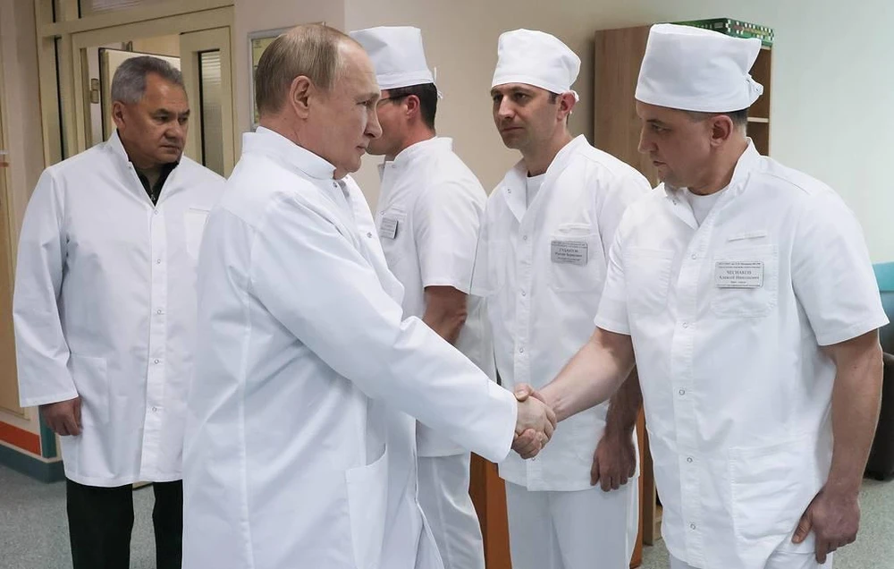 Tổng thống Nga Vladimir Putin bắt tay với các nhân viên y tế đang điều trị cho những binh sĩ bị thương trong cuộc xung đột ở Ukraine vào ngày 25-5. Ảnh: TASS