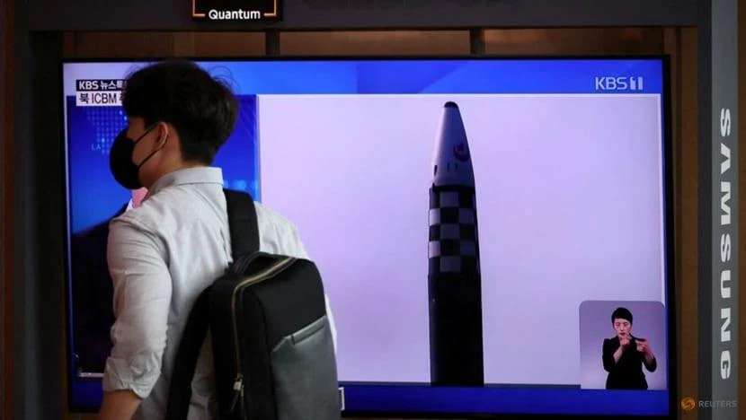 Một người đàn ông đi ngang qua màn hình TV đang phát bản tin về việc Triều Tiên phóng ba tên lửa vào ngày 25-5. Ảnh: REUTERS