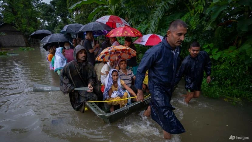 Binh sĩ sơ tán dân làng bằng một chiếc thuyền ở làng Jalimura, phía tây TP Gauhati, bang Assam (Ấn Độ), ngày 18-6. Ảnh: AP