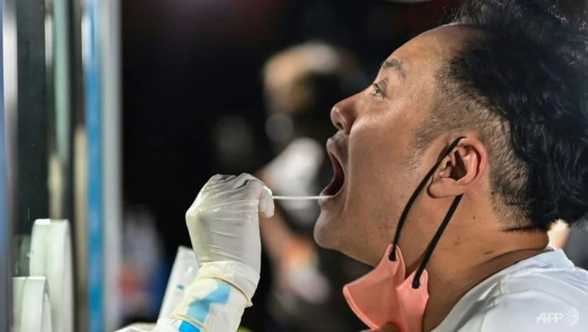 Nhân viên y tế đang lấy mẫu xét nghiệm từ một người đàn ông. Ảnh: AFP