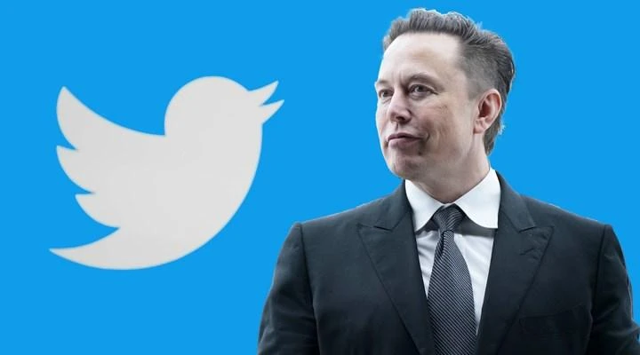 Tỉ phú Elon Musk đứng trước logo nền tảng mạng xã hội Twitter. Ảnh: REUTERS
