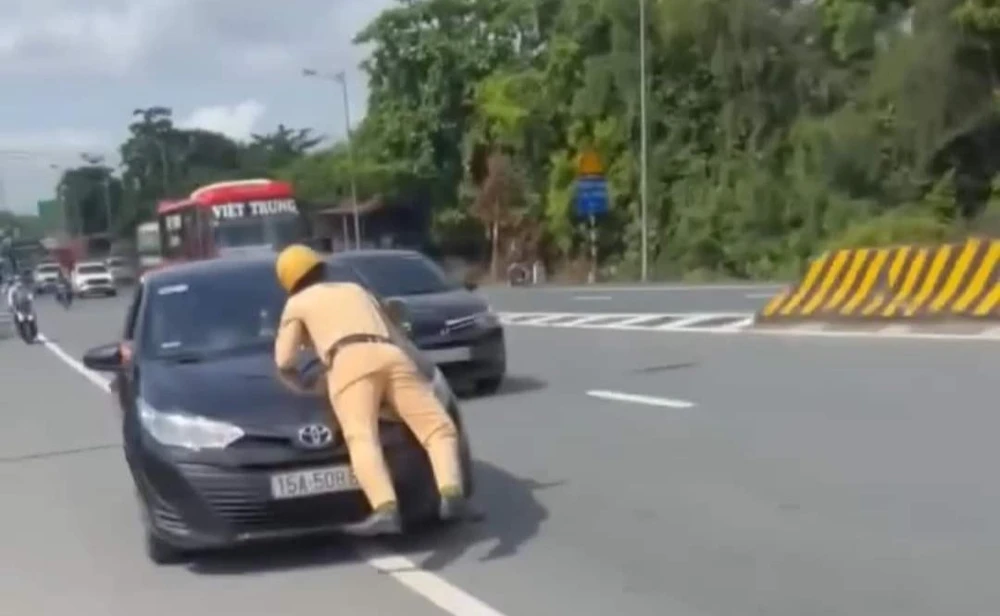 Cảnh sát giao thông bị hất lên nắp capo khi chiếc xe cố tình bỏ chạy. Ảnh cắt clip