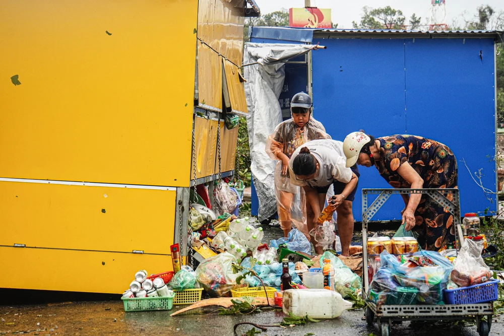 Bà Lương Thị Phi, người dân ở tổ 2 phường Vạn Hương đang thu dọn Kios sau khi Kios của bà bị bão số 3 quật bay. 'Gần 70 năm sinh sống ở đây, đây là lần đầu tiên tôi thấy có cơn bão mạnh và kéo dài như vậy. Bão đi kèm với gió giật liên tục trong khoảng 6-7 giờ đồng hồ' - bà Phi nói. Ảnh: NGỌC SƠN