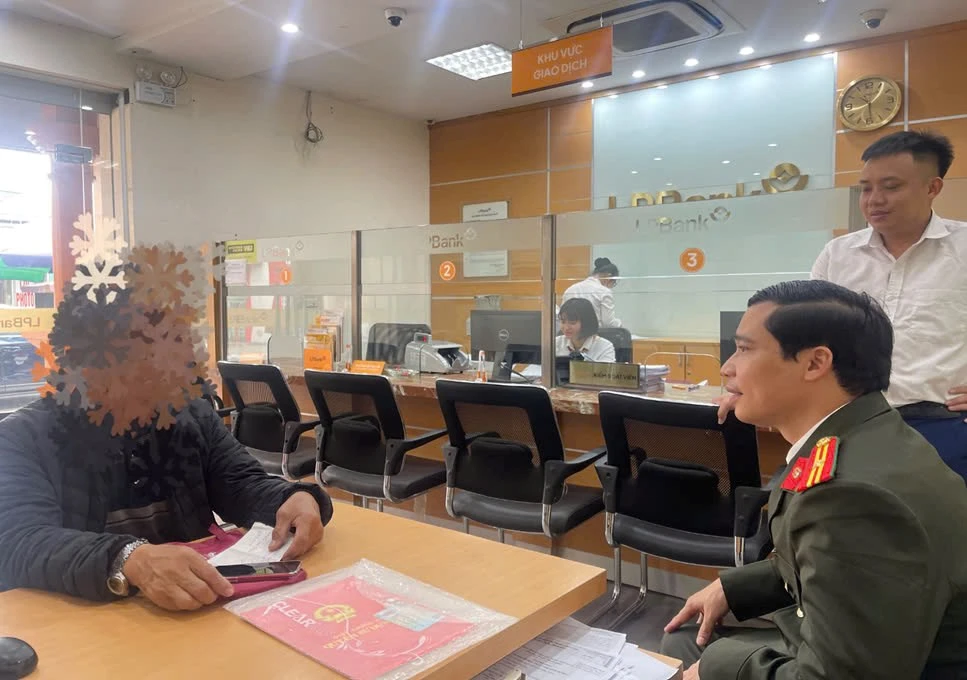 Công an giải thích cho ông C. tránh bị lừa đảo khi đến vay ngân hàng để chuyển tiền cho người lạ. Ảnh: CAHP