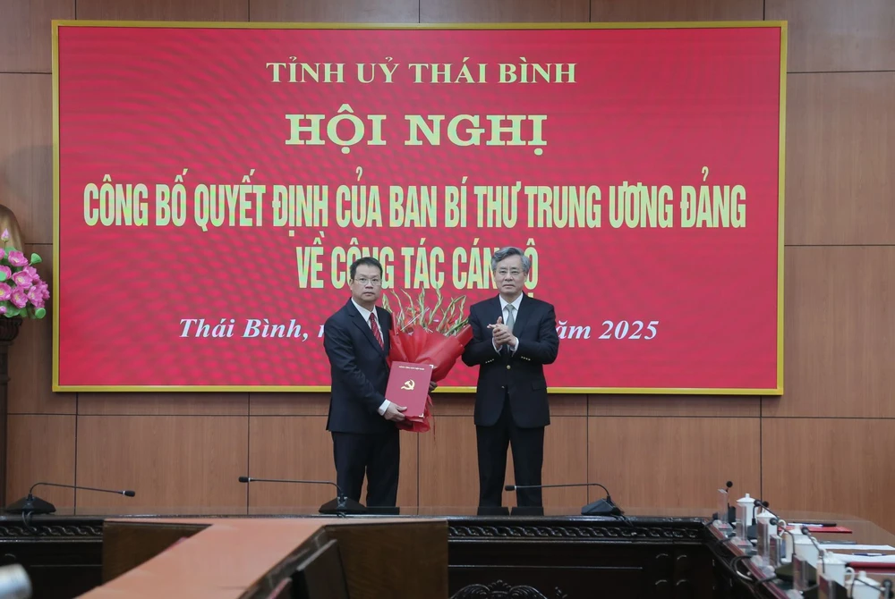 Ông Nguyễn Quang Dương (phải), Phó Trưởng Ban Tổ chức Trung ương trao quyết định và tặng hoa chúc mừng ông Nguyễn Mạnh Hùng, tân Phó Bí thư Tỉnh ủy Thái Bình. Ảnh: TĐ