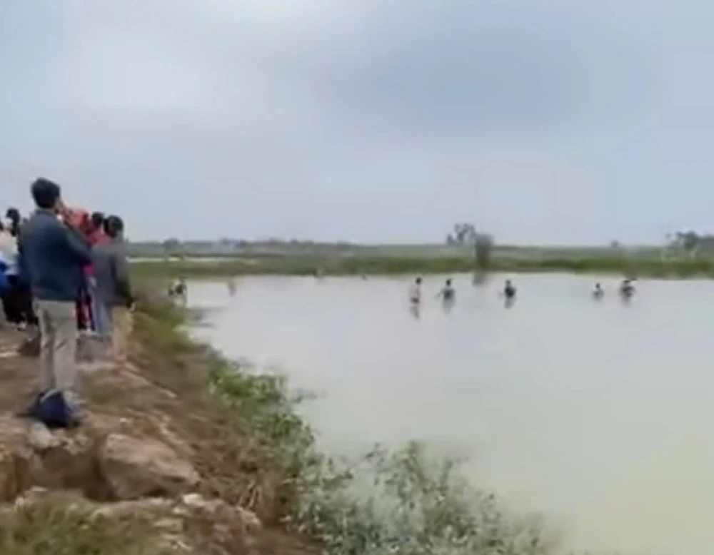 Lực lượng chức năng, người dân tìm kiếm thi thể của hai cháu học sinh lớp 5 bị đuối nước. Ảnh cắt clip