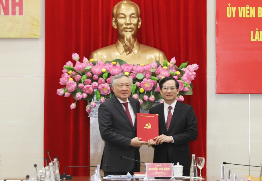 Phó Thủ tướng Thường trực Chính phủ Nguyễn Hòa Bình thừa ủy quyền trao quyết định chuẩn y của Ban Bí thư cho ông Vũ Quyết Tiến, Phó Bí thư Tỉnh ủy Quảng Ninh. Ảnh: QMG