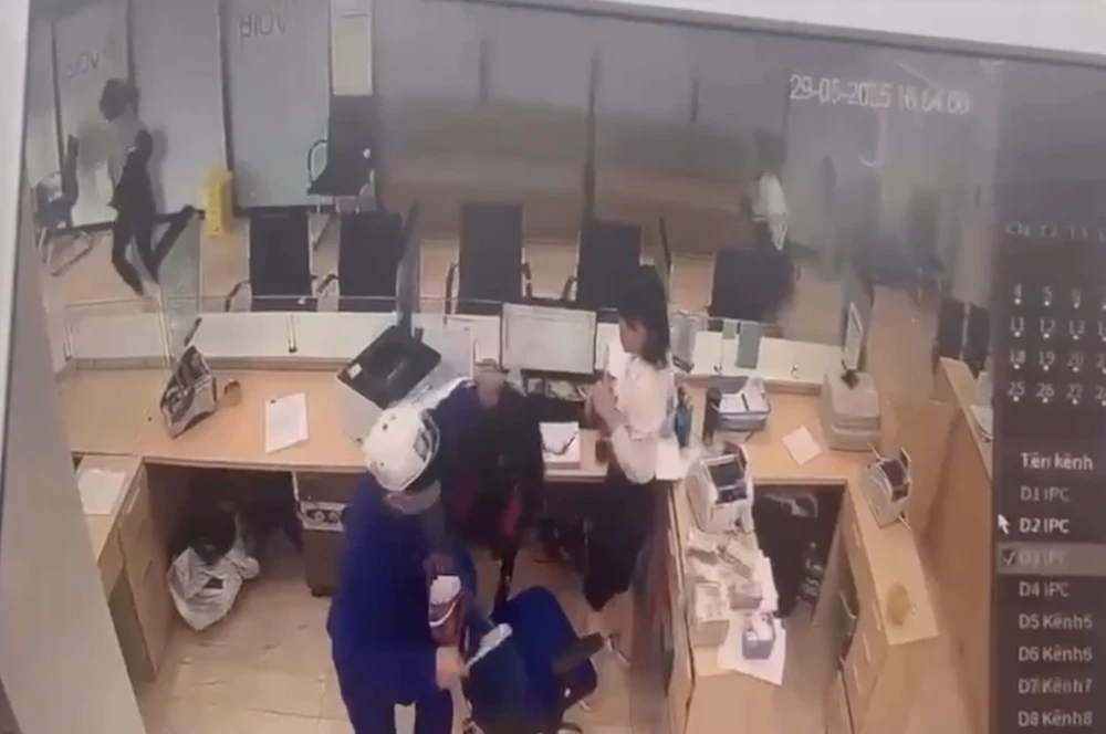 Người đàn ông cầm theo vật nghi là dao để cướp ngân hàng. Ảnh chụp từ clip