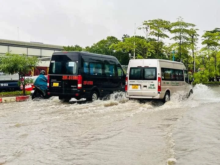 Nước ngập cao lên trên cả vỉa hè khiến các phương tiện di chuyển khó khăn. Làn ô tô tắc đường kéo dài, xe máy hầu như không thể đi lại được. Ảnh: CTV
