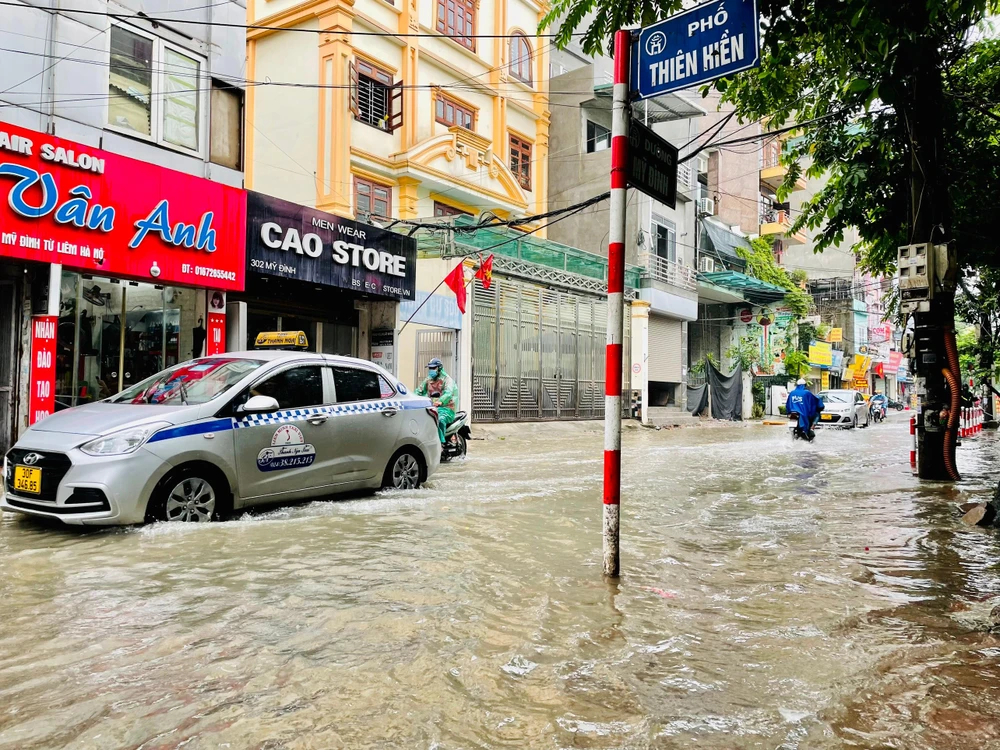 Ngã 3 giao giữa đường Mỹ Đình và phố Thiên Hiền (quận Nam Từ Liêm) vẫn ngập khá sâu, luôn phải có đơn vị cấp thoát nước túc trực để phân luồng giao thông. Ảnh: NHƯ LOAN