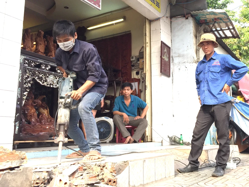Bậc thềm trước nhà số 65 Trường Chinh choài ra chiếm vỉa hè, đã được khoan đục để tháo dỡ sáng 14-3.