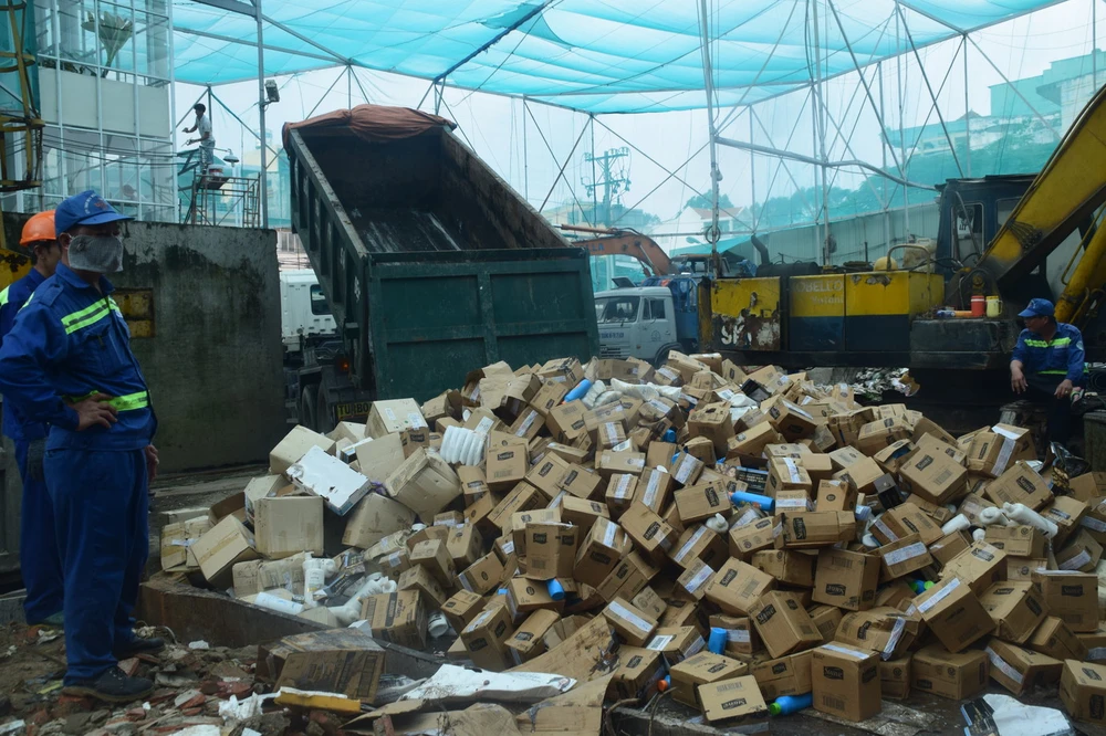 Lực lượng chức năng tiêu hủy hàng giả. Ảnh: Tú Uyên