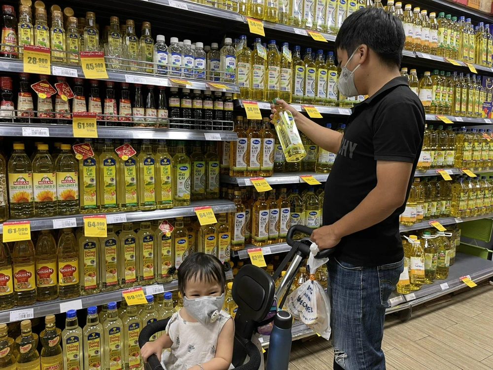 Người dân đang lựa chọn dầu ăn. ẢNH: NGUYÊN HÀ