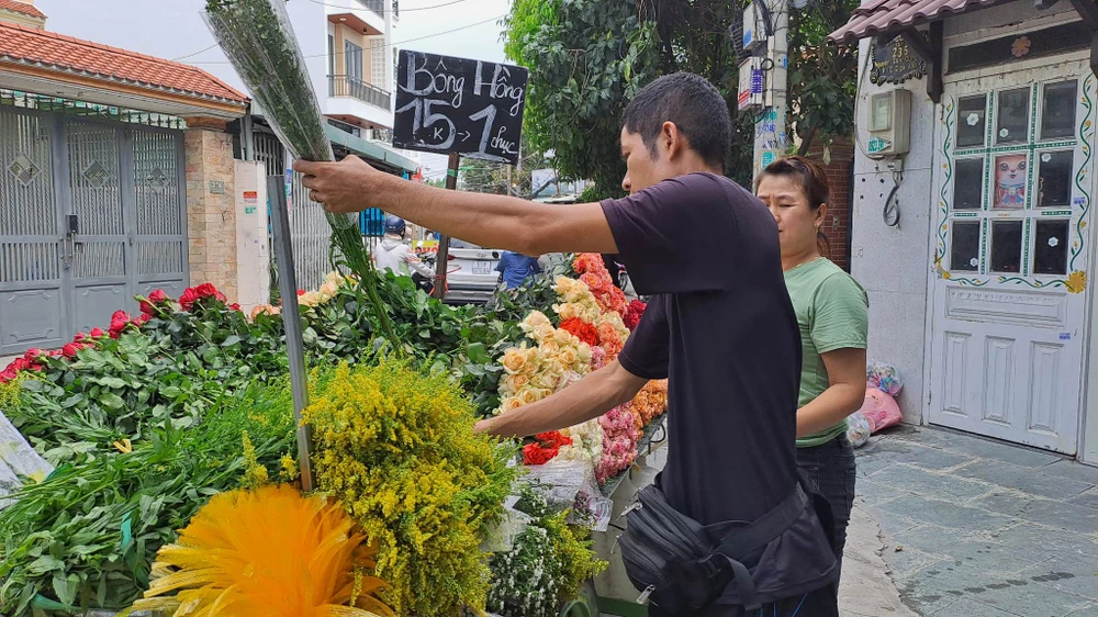 Hoa hồng đang được bán ở các xe đẩy với giá 15.000 đồng và được tặng kèm hoa trang trí khi mua. ẢNH: THU HÀ