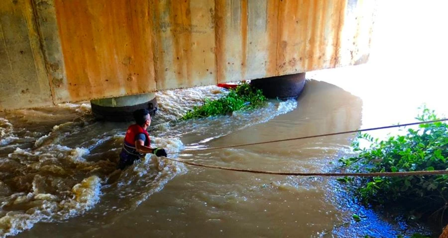 Lực lượng cứu hộ kiểm tra các trụ cầu và gặp khó khăn khi nước thượng nguồn đang đổ về rất mạnh.