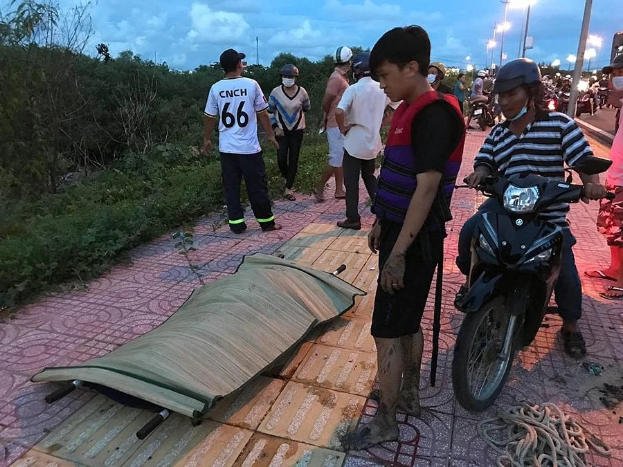 Một chiến sĩ cứu nạn đứng thẫn thờ bên thi thể em D vừa được tìm thấy. Ảnh HD.