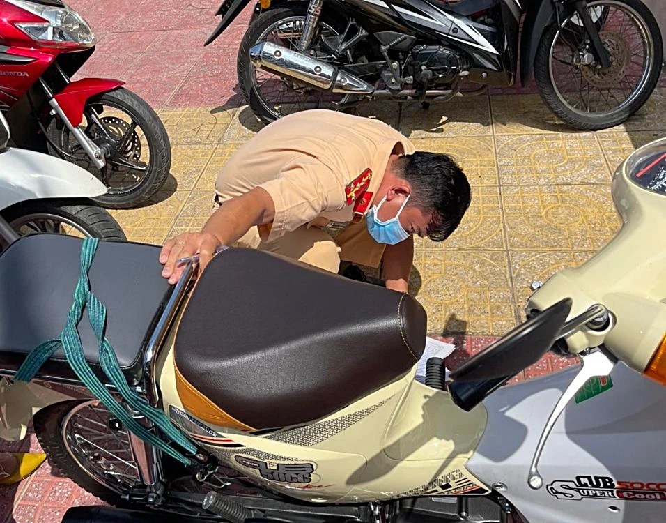 Kiểm tra số khung, số máy để làm thủ tục đăng ký xe. Ảnh PĐ.