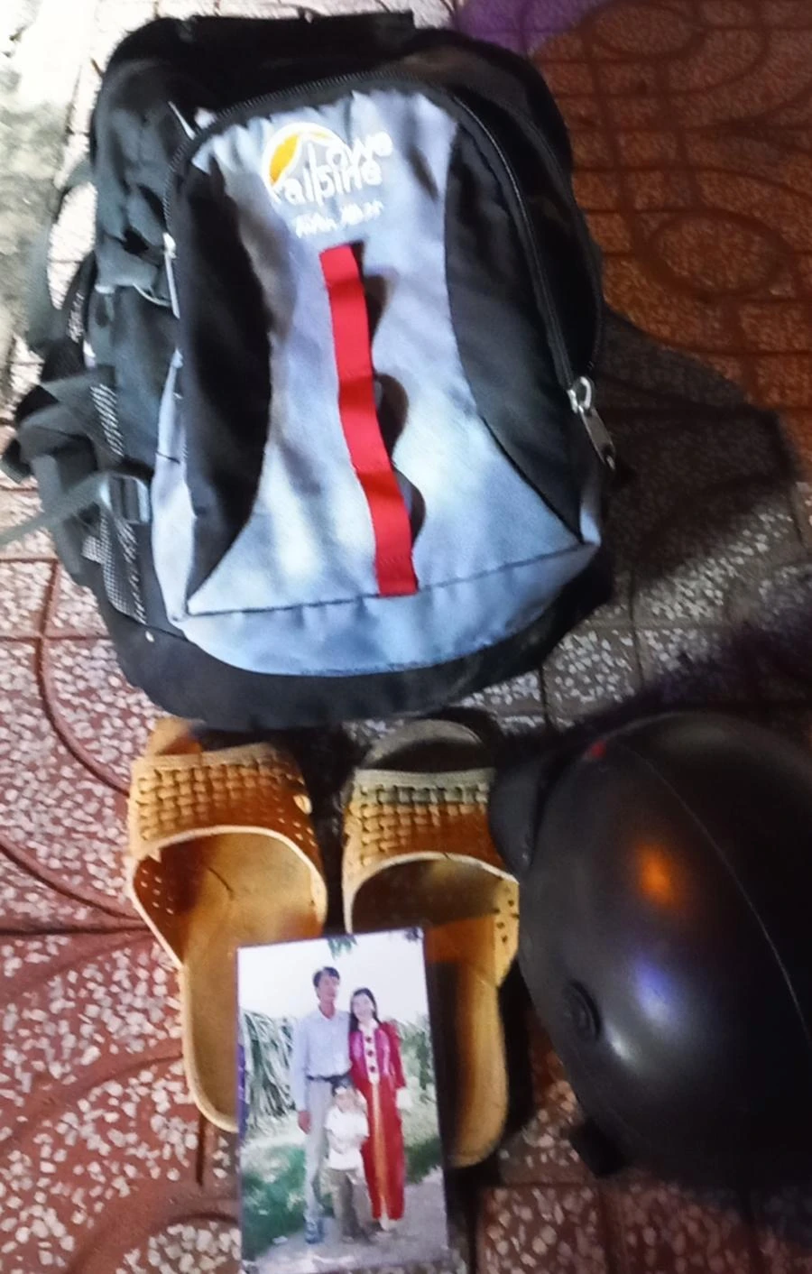 Đồ đạc người thanh niên để lại trên cầu Cà Ty, phía sau tấm ảnh là số điện thoại người mẹ. Ảnh PĐ.