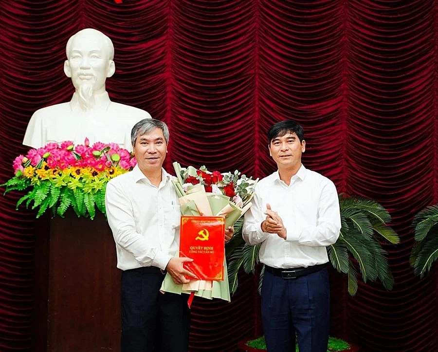 Ông Dương Văn An (phải) trao quyết định và tặng hoa chúc mừng ông Nguyễn Văn Quang. Ảnh TH.